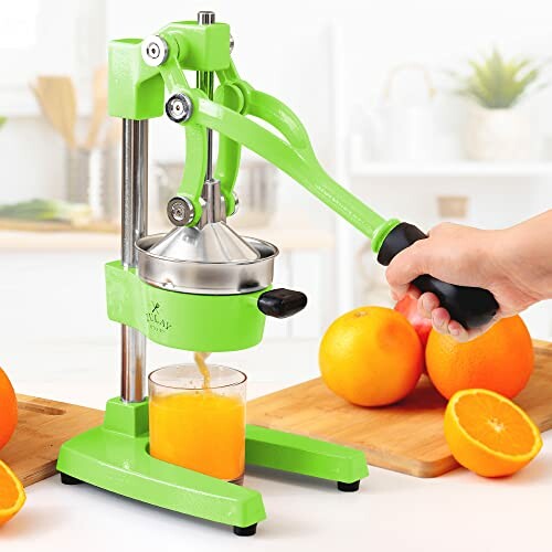 Hand pressing oranges with a manual juicer.