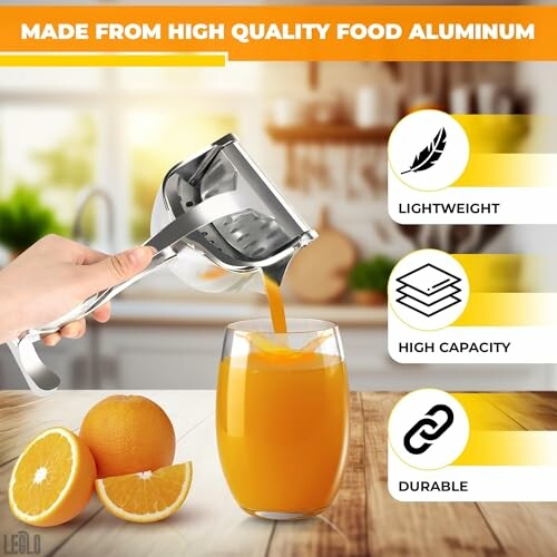 Hand using metal juicer to pour orange juice into glass